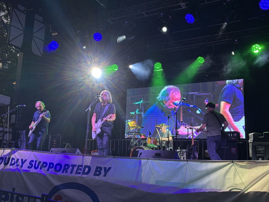 Stone The Radio on the main stage under blue and green lights with the video screen behind
