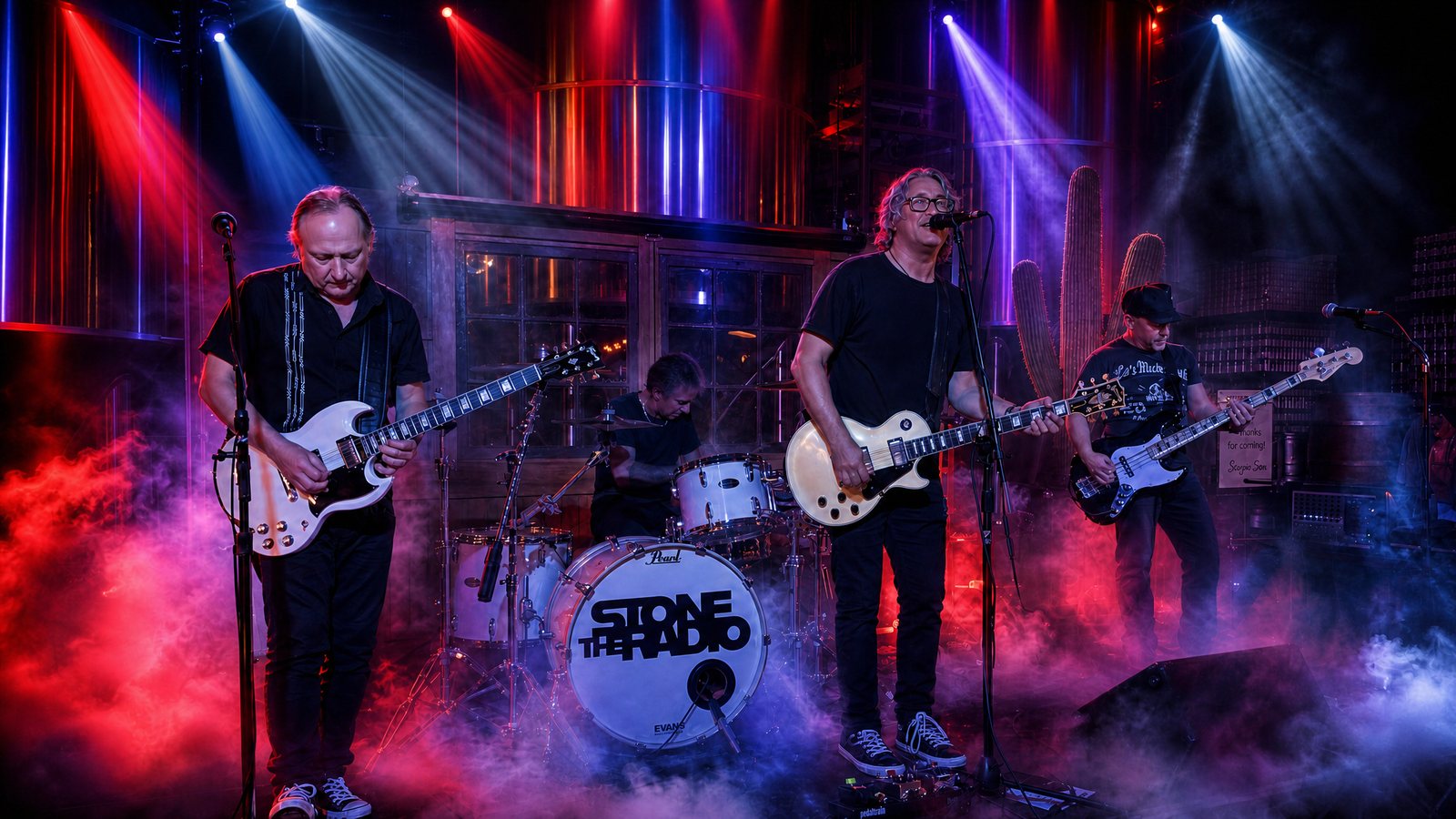 Stone The Radio on stage in a haze of red and blue light, their name lit up on the bass drum